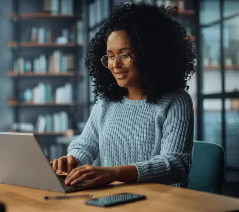 Woman with curvy hair working on laptop