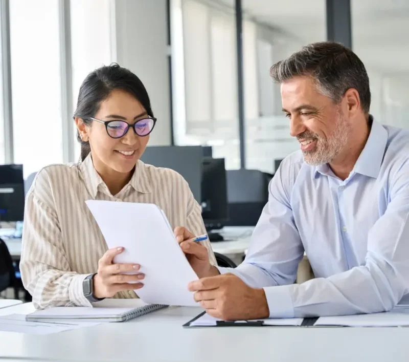 Two bank employees reviewing documents.