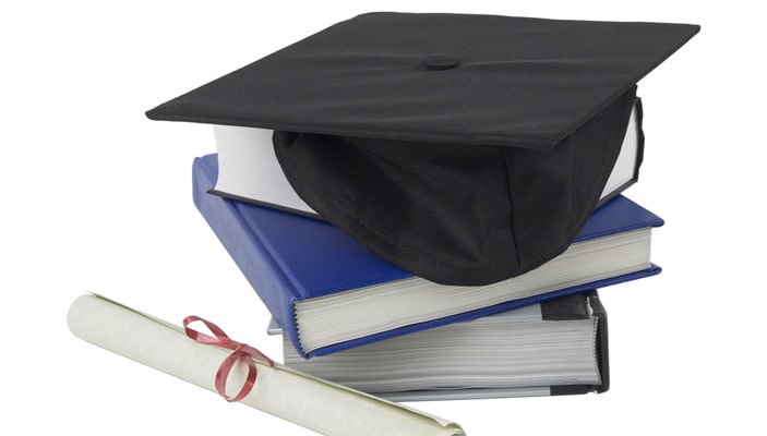 Graduation cap on top of the stack of books.